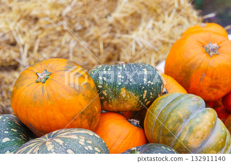 Colorful of orange and green pumpkins and gourds on dry straw background, autumn harvest season 132911140