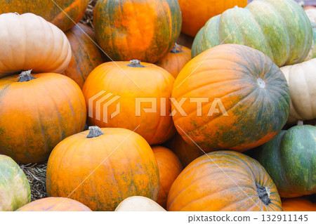 Stack, pile of colorful autumn pumpkins of various shapes and sizes, seasonal harvest background 132911145