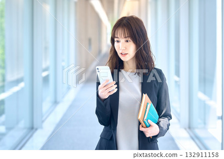 一位女商人對她的智慧型手機感到驚訝的肖像 132911158