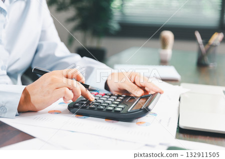 Businesswoman manages finances by using banking and accounting system to calculate costs, taxes, investments, illustrating a business, finance, and real estate concept focused on financial strategy. Businesswoman manages finances by using banking and accounting system to calculate costs, taxes, investments, illustrating a business, finance, and real estate concept focused on financial strategy. 132911505