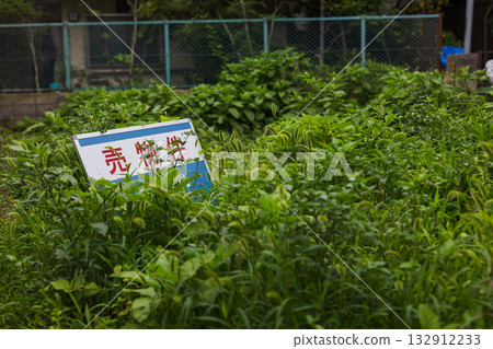 A for-sale sign on a vacant lot in a residential area 132912233