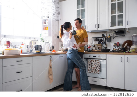 Husband and wife are romantically chatting in the kitchen in the morning 132912630