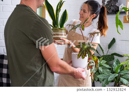 A husband gives his wife a potted plant for a hobby A husband gives his wife a potted plant for a hobby 132912824