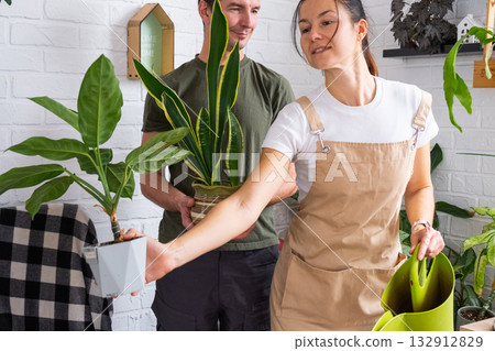 A husband gives his wife a potted plant for a hobby A husband gives his wife a potted plant for a hobby 132912829
