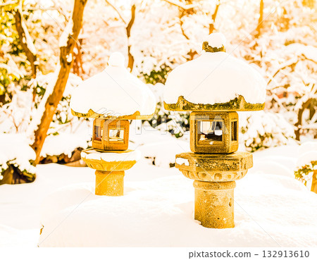夕陽的餘暉照亮了雪燈和寧靜的花園。 132913610