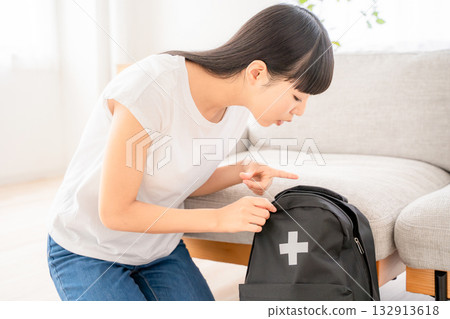 一名年輕女子正在檢查防災物資。 一名年輕女子正在檢查防災物資。 132913618