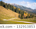 Autumn colors on Altopiano di Asiago, Italy. A winding dirt road leads through a mountain landscape 132913853