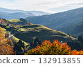Autumn colors paint the Altopiano di Asiago hillsides with a village nestled below 132913855