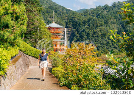 Smiling woman explores Nachi Falls and Seigantoji Temple, a beautiful Japanese cultural site 132913868