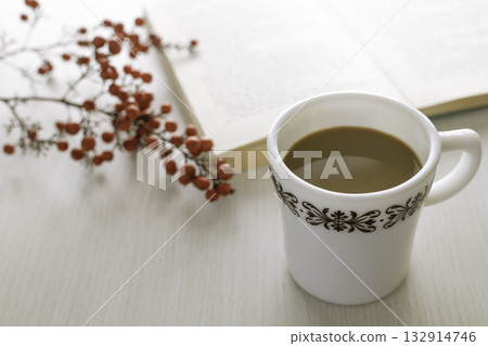 A quiet afternoon spent with a book and coffee: soft light shining on a winter table 132914746