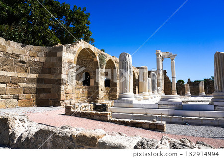 Exploring Ancient Architecture: A Journey Through Historical Ruins with Towering Columns and Arched Structures Under a Clear Blue Sky 132914994