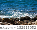 Captivating View of Gentle Waves Interacting with Rocky Shoreline Under Bright Sunny Daylight 132915052
