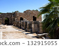 Ancient Ruins Surrounded by Nature: A Stunning View of Weathered Stone Structures Against a Clear Blue Sky and Lush Greenery 132915055