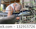 A man repairs an old motorcycle with a sidecar 132915726