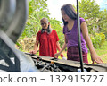Women look under the hood of a broken car to find engine problems 132915727