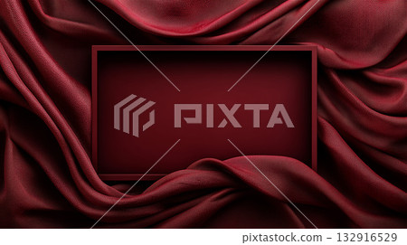 A simple frame in the same color is placed in the center of a smooth burgundy fabric drape. A simple frame in the same color is placed in the center of a smooth burgundy fabric drape. 132916529