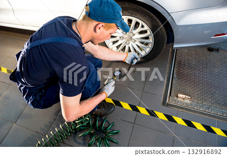 Professional car mechanic working with in auto repair service. Repair of wheels 132916892
