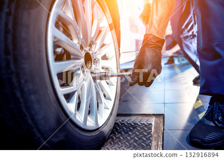 Professional car mechanic working with in auto repair service. Repair of wheels Professional car mechanic working with in auto repair service. Repair of wheels 132916894