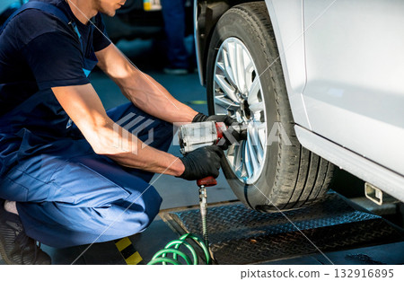 Professional car mechanic working with in auto repair service. Repair of wheels 132916895