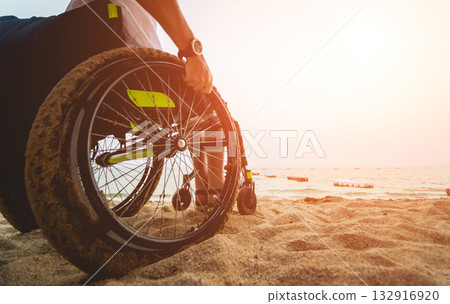 Disabled man in a wheelchair on the beach. Disabled man in a wheelchair on the beach. 132916920