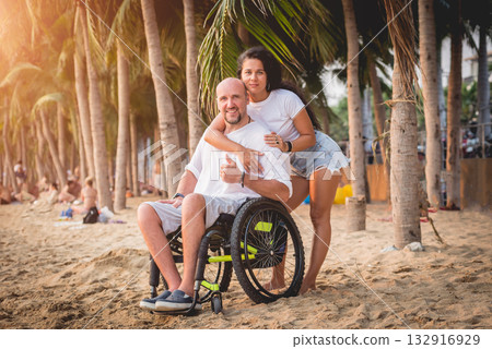Disabled man in a wheelchair with his wife on the beach. 132916929