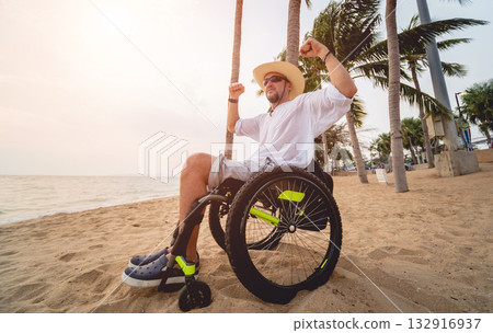 Disabled man in a wheelchair on the beach. Disabled man in a wheelchair on the beach. 132916937