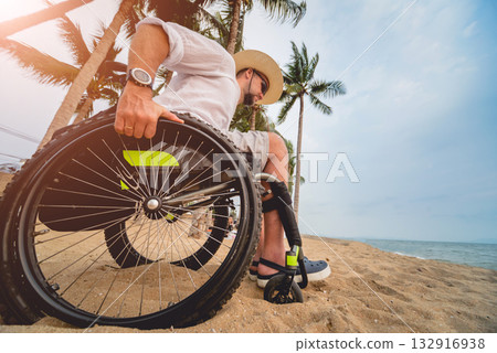 Disabled man in a wheelchair on the beach. Disabled man in a wheelchair on the beach. 132916938