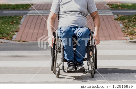 Handicapped man in wheelchair crossing street road Handicapped man in wheelchair crossing street road 132916959