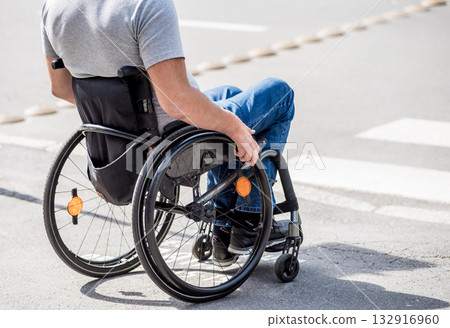 Handicapped man in wheelchair preparing to cross the road on pedestrian crossing Handicapped man in wheelchair preparing to cross the road on pedestrian crossing 132916960