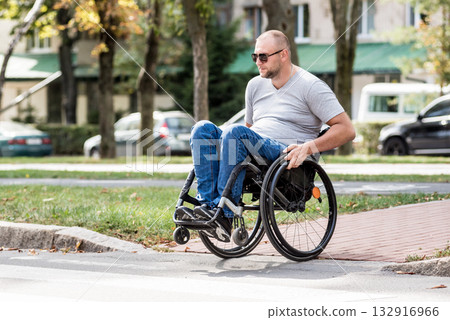 Handicapped man in wheelchair crossing street road Handicapped man in wheelchair crossing street road 132916966