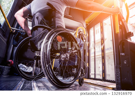 A man in a wheelchair inside of a specialized vehicle  132916970