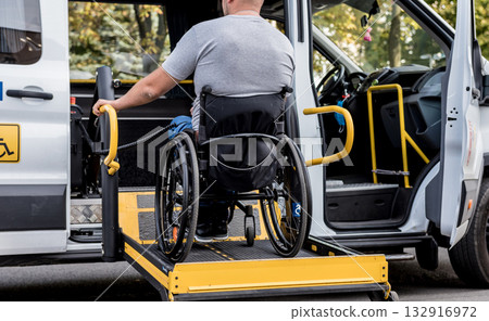 A man in a wheelchair on a lift of a vehicle for people with disabilities 132916972