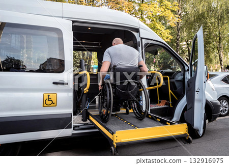 A man in a wheelchair on a lift of a vehicle for people with disabilities A man in a wheelchair on a lift of a vehicle for people with disabilities 132916975