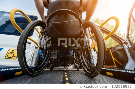 A man in a wheelchair on a lift of a vehicle for people with disabilities 132916982