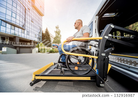 A man in a wheelchair on a lift of a vehicle for people with disabilities A man in a wheelchair on a lift of a vehicle for people with disabilities 132916987