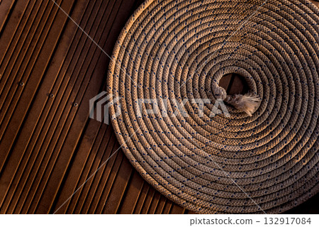 Ship rope on the yacht deck. Wooden background. 132917084