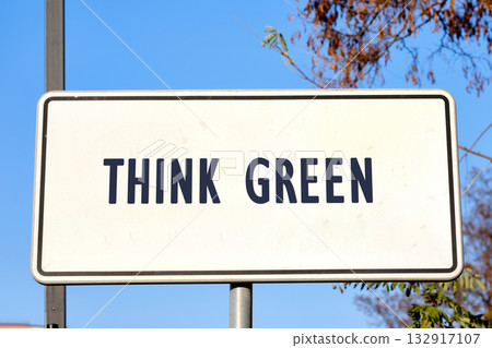 A bold sign stands prominently against a bright blue sky, urging passersby to embrace eco-friendly practices by thinking green. The message is clear and inspiring A bold sign stands prominently against a bright blue sky, urging passersby to embrace eco-friendly practices by thinking green. The message is clear and inspiring 132917107