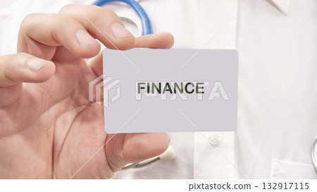 A person holds a card with the word finance, emphasizing the connection between financial literacy and health care decisions. This moment captures the importance of financial planning 132917115
