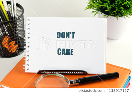 A notepad with the words dont care boldly displayed sits on a colorful desk, surrounded by office supplies and a plant, creating a vibrant workspace full of motivation A notepad with the words dont care boldly displayed sits on a colorful desk, surrounded by office supplies and a plant, creating a vibrant workspace full of motivation 132917137