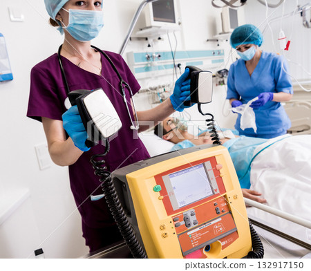 Doctors give resuscitation to a male patient in the emergency room. 132917150