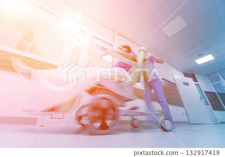 Nurse moves mobile medical chair with patient at hospital. Medical equipment. 132917419