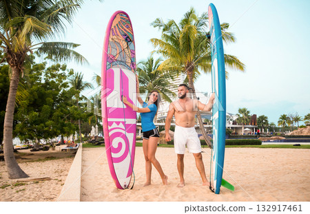Two young surfers with boards on the beach 132917461