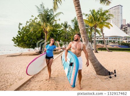 Two young surfers with boards on the beach Two young surfers with boards on the beach 132917462