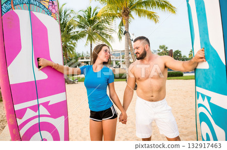 Two young surfers with boards on the beach 132917463