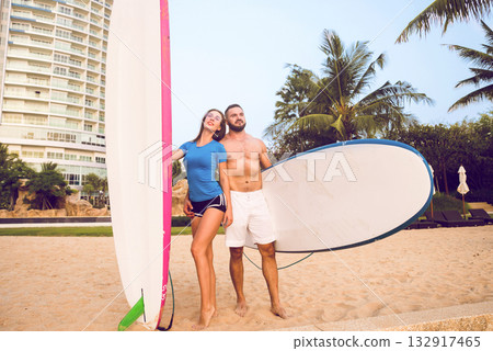 Two young surfers with boards on the beach Two young surfers with boards on the beach 132917465