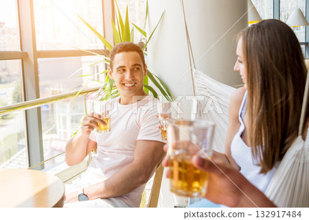 Cheerful friends in the pub. Drinking beer, talking, having fun. 132917484