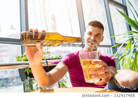 Young man in the pub. Drinking beer, eating pizza. Young man in the pub. Drinking beer, eating pizza. 132917488