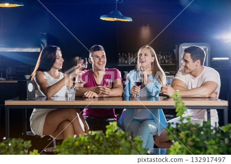 Cheerful friends in the pub. Drinking beer, wine and whisky Cheerful friends in the pub. Drinking beer, wine and whisky 132917497