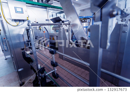 Bottling line of sunflower oil in bottles. Vegetable oil production plant. Bottling line of sunflower oil in bottles. Vegetable oil production plant. 132917673