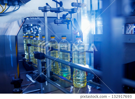 Bottling line of sunflower oil in bottles. Vegetable oil production plant. Bottling line of sunflower oil in bottles. Vegetable oil production plant. 132917693